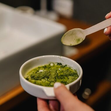 A person prepares matcha tea in a modern bathroom, capturing a calming home ritual.